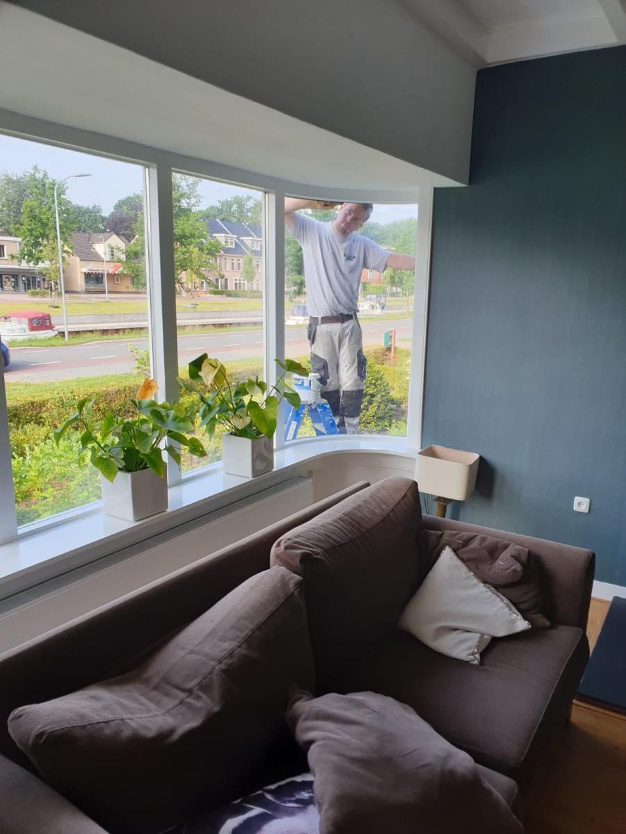 Woonkamer met groot raam en een donkere wand