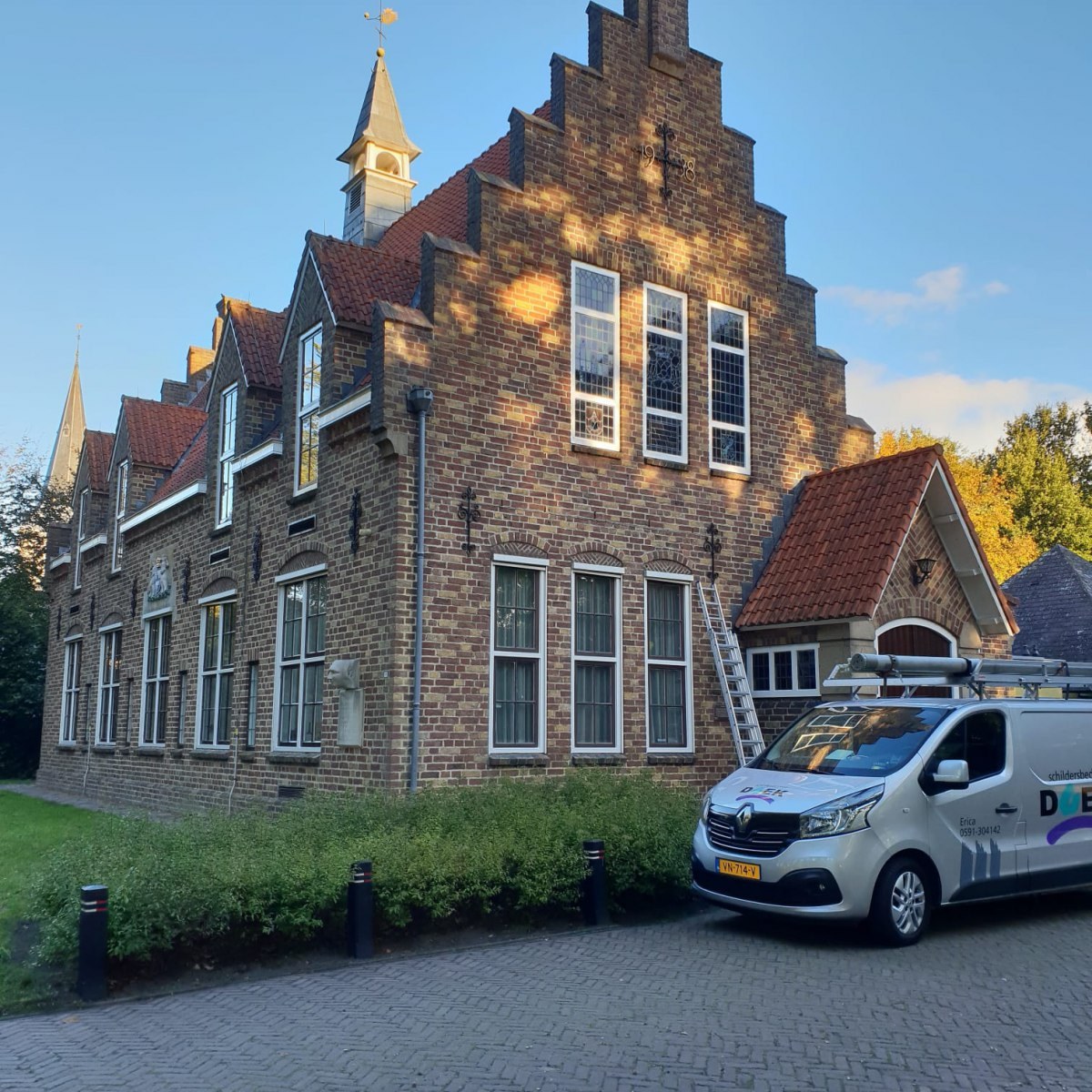 Monumentaal ogend bakstenen pand met trapgevel en bedrijfsbus
